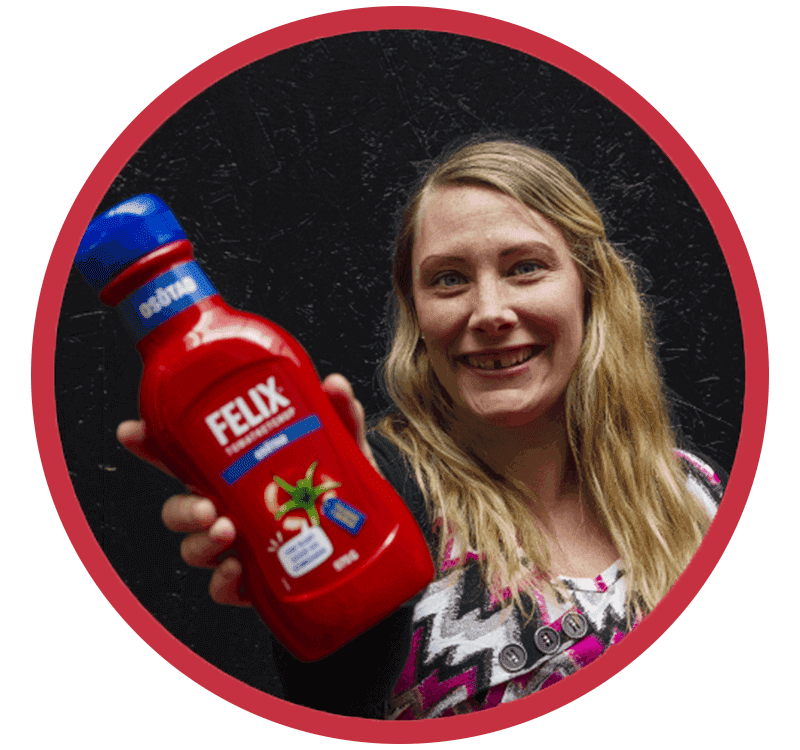Glad tjej som håller en flaska Felix osötade ketchup