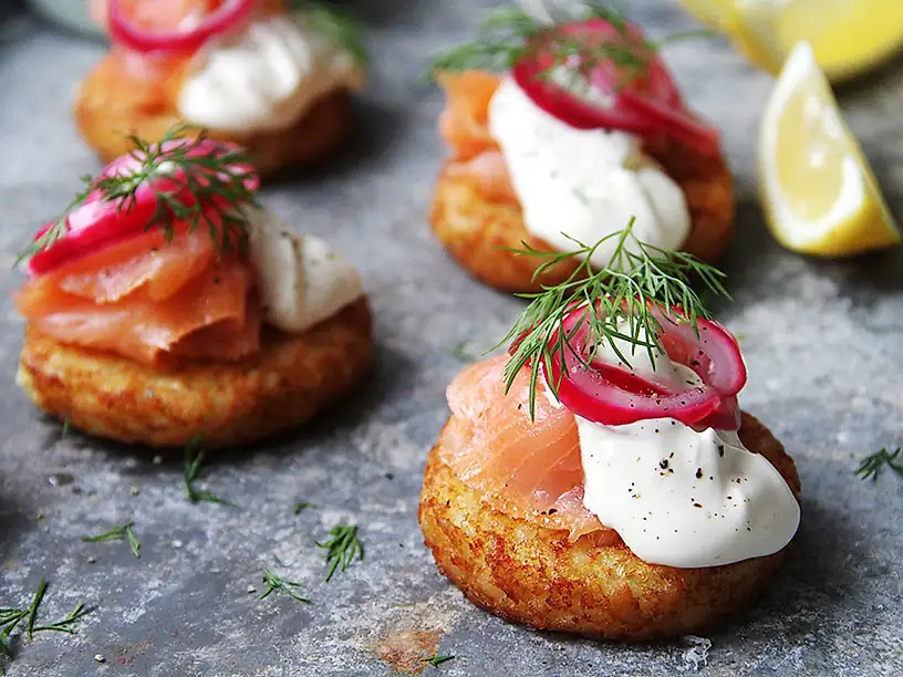 Potatisbullar toppade med lax, creme fraiche, rödlök och dill