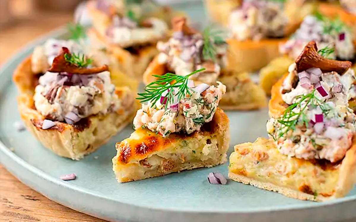 Fat med snittar av ostpaj med Västerbottensost toppad med kantarell- och kräftröra.