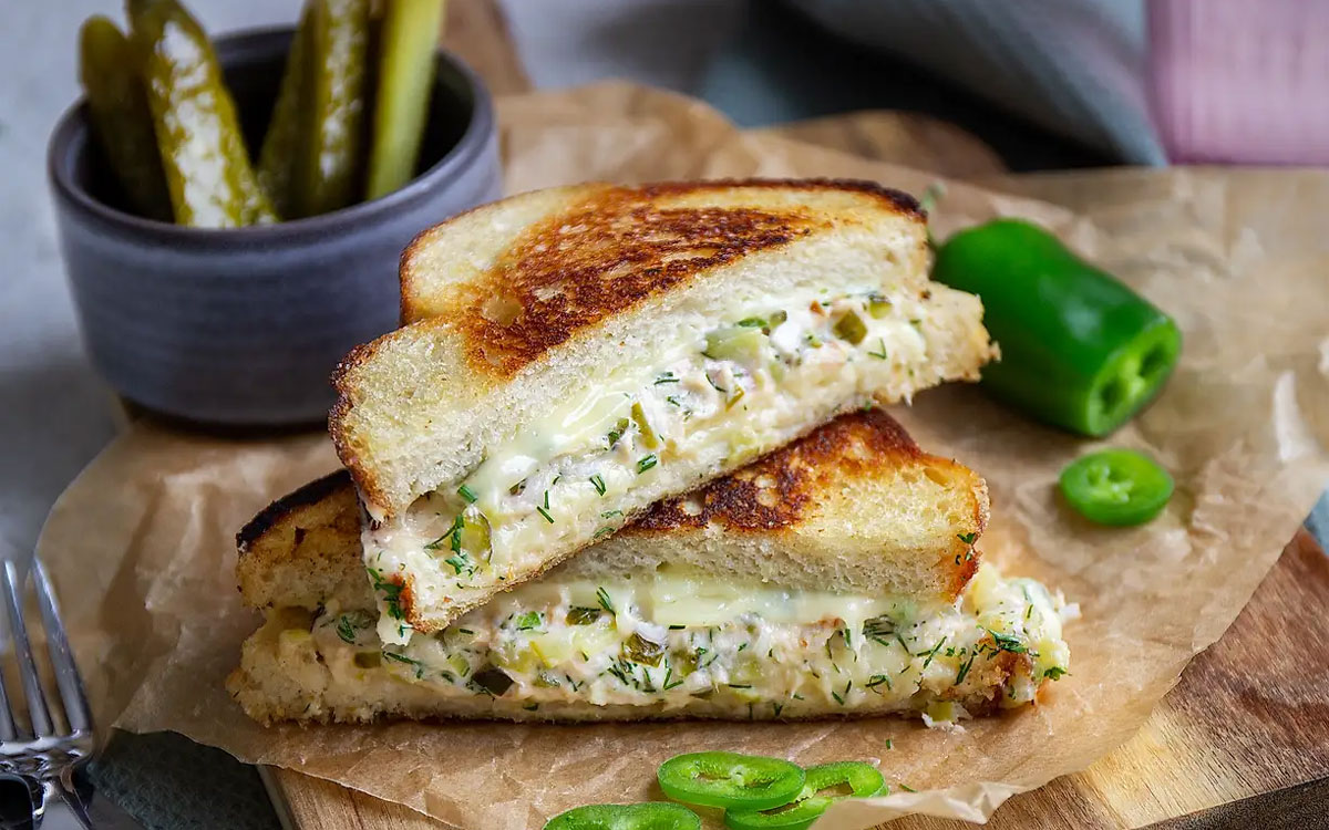 Skärbräda med salmon melt toast uppskuren, saltgurka, jalapeno.