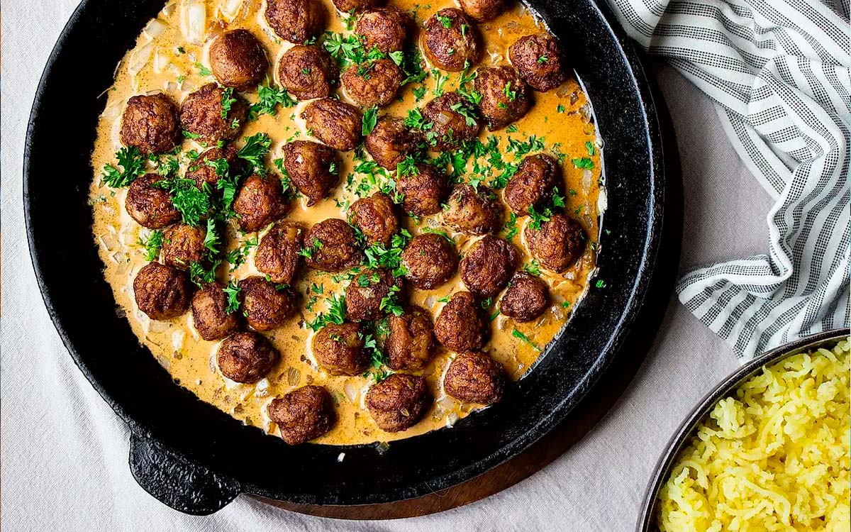 Stekpanna med köttbullar i gräddsås med hackad persilja.