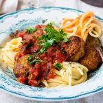 Tallrik med pasta med vegobullar i mustig tomatsås.