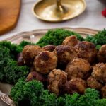 Fat med klassiska julköttbullar kantade med grönkålsblad.