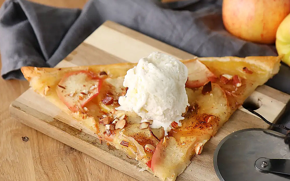 Frasig smördegspizza med äpple och kanel toppad med en kul vaniljglass.