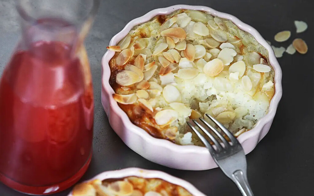Portionsskål med rispudding toppad med mandelflarn.