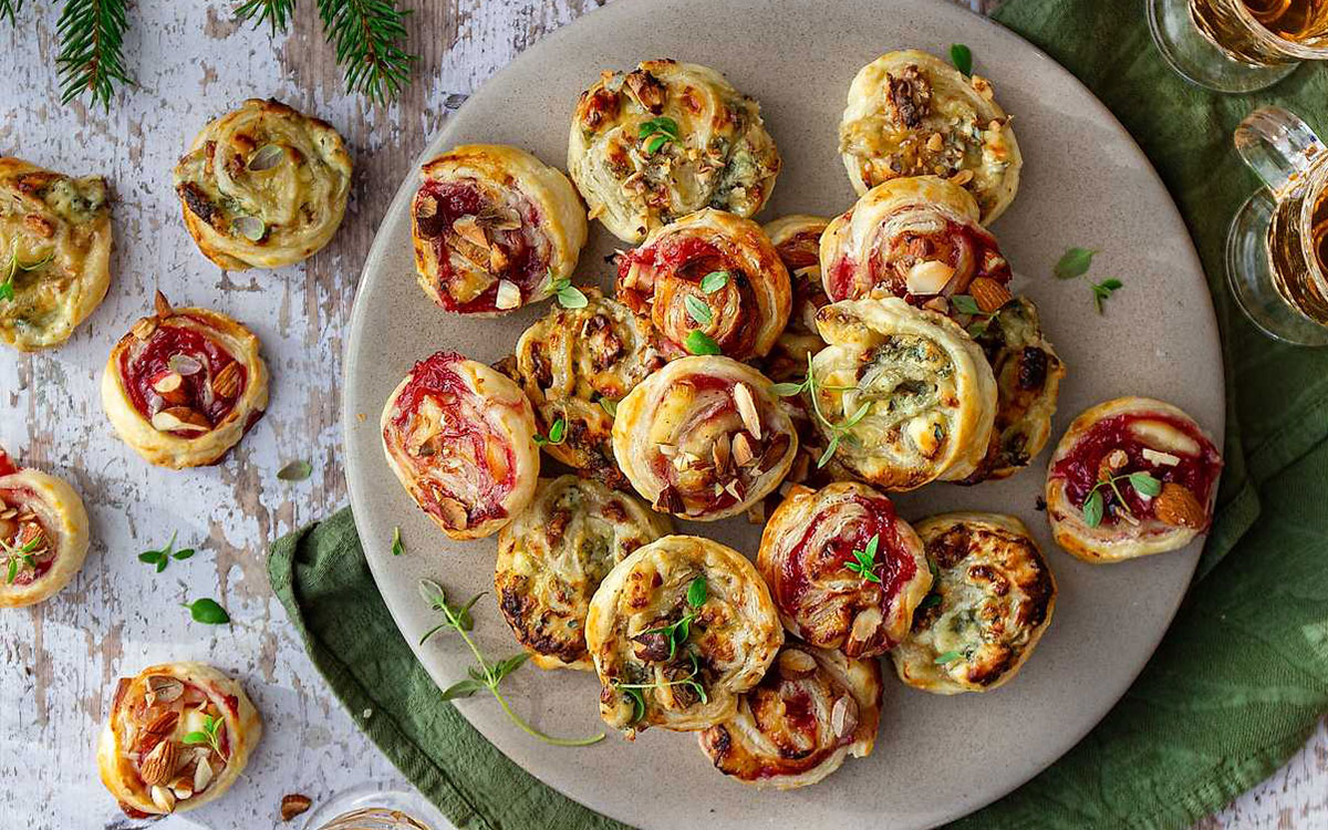 Tallrik med två varianter av smördegssnittar gjorda på äpple och ädelost samt lingon och brie.