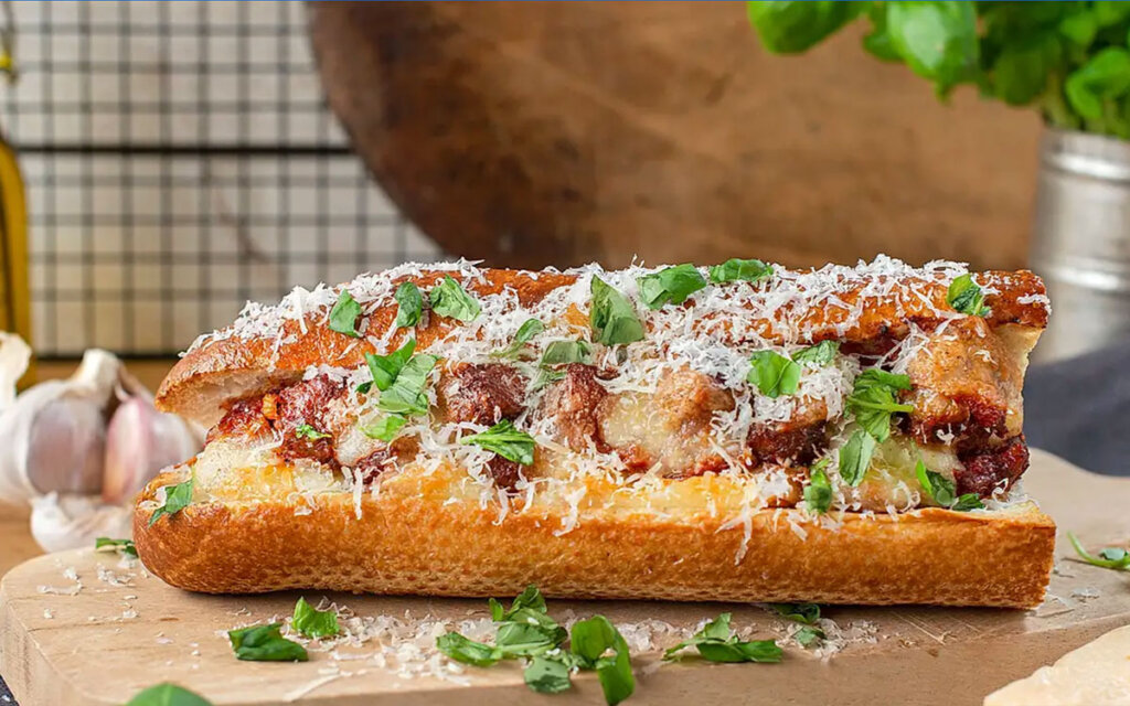 Meatball sub med köttbullar i het tomatsås och gratinerad mozzarella toppad med färsk basilika.