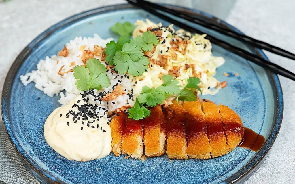 Tallrik med vegetarisk tonkatsu med ris, krämig kålsallad och sesammajonnäs.