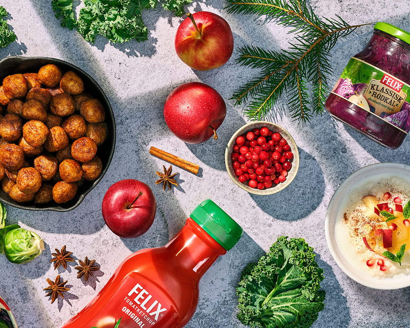 Uppdukat bord med stekpanna med köttbullar, Felix ketchup, rödkål och risgröt.