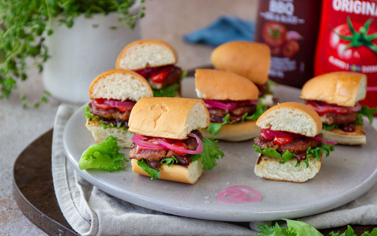 Tallrik med minisliders gjorda av smashade köttbullar och delade korvbröd.