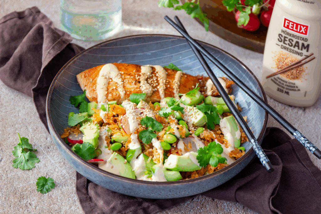 Bowl med crispy rice salad med lax, avokado, koriander toppad med Felix mörkrostade sesamdressing.