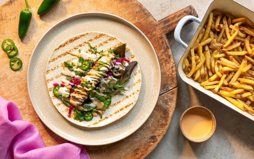 Tallrik med kebabspett av lammfärs i ett tortilliabröd med sallad och Felix kebabsås, pommes.