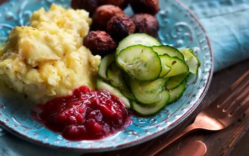 Tallrik med köttbullar, potatismos, llingon och pressgurka.