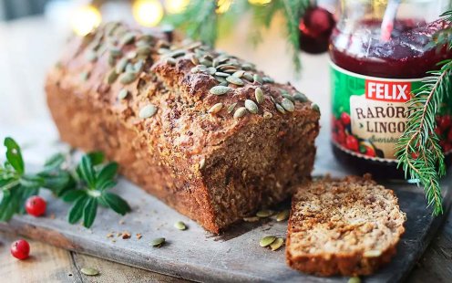 Lingonlimpa med en uppskuren skiva på en skärbräda. En burk med Felix lingonsylt bredvid.